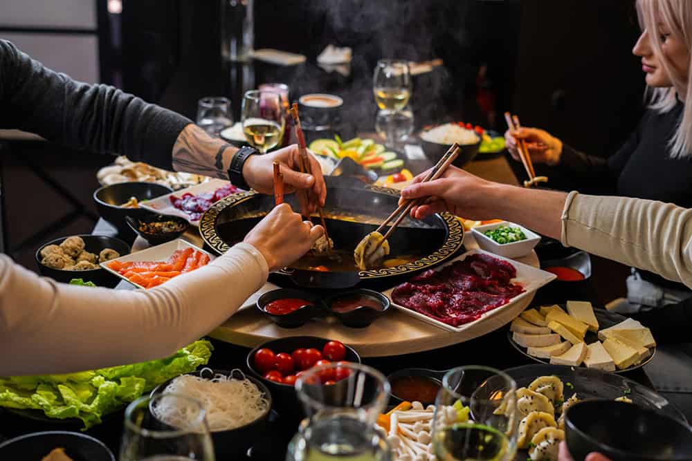 O masă cu mâncare chinezească, sushi și sosuri, pentru o experiență culinară autentică.