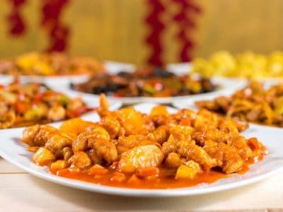 Descriere alt text: Tablou cu diverse preparate chinezești dulci, prezentate pe farfurii, reprezentâ.