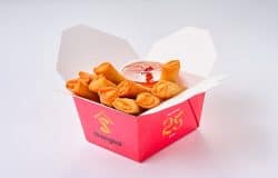 Pachețele de primăvară cu legume, servite cu sos dulce-acrișor, în ambalaj tradițional chinezesc.